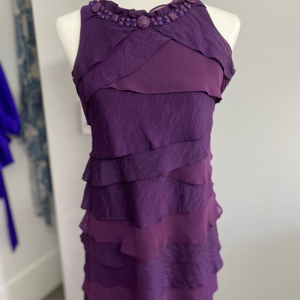 Purple cocktail dress with vexed detail at neckline